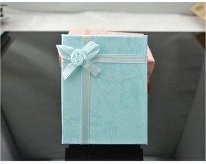 Detail of light blue and pink jewelry gift boxes with marble texture and ribbon rose decor