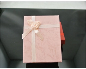 Detailed view of pink marble-patterned jewelry gift box with ribbon and rose decoration