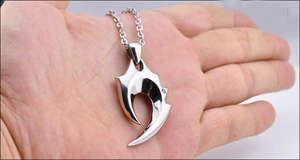 Macro detail of gothic skull claw pendant with zircon stone and polished cross chain