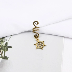 Close-up of golden spiral hair clip featuring a detailed rudder pendant for braids