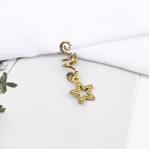 Detailed macro view of a gold spiral hair ring with a vintage star-shaped pendant charm