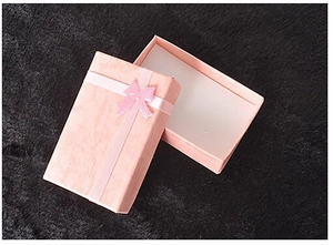 Detailed view of pink jewelry gift box with ribbon bow and soft white padded interior