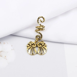 Macro shot of vintage gold spiral dreadlock hair clip with hollow filigree butterfly pendant