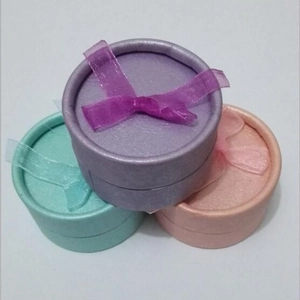 Textured round jewelry gift boxes with chiffon bows in purple, teal, and pink colors