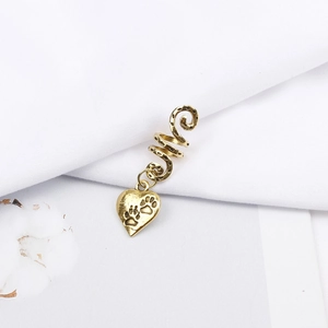 Detail of a vintage gold spiral hair braid accessory featuring a heart paw pendant