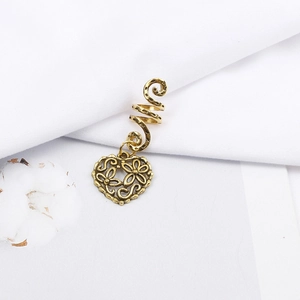 Detail of vintage gold spiral hair coil with intricate hollow heart pendant and floral carving