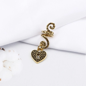 Detailed close-up of retro gold spiral hair cuff featuring a textured heart lock pendant