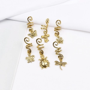 Detailed view of six vintage gold alloy dreadlock spirals with assorted animal charms