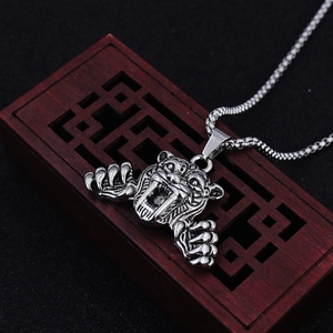 Détail macro du pendentif tête de tigre en argent antique sur boîte en bois