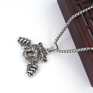 Vue détaillée du pendentif tête de tigre en argent avec sa chaîne à mailles carrées