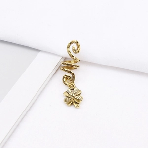 Detailed macro view of a golden spiral hair ring featuring a clover charm and vintage texture