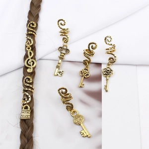 Detail of vintage gold alloy hair rings with key, lock and music note pendants for braids