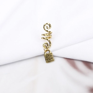 Detail of vintage gold spiral hair rings with engraved lock charms for dreadlocks