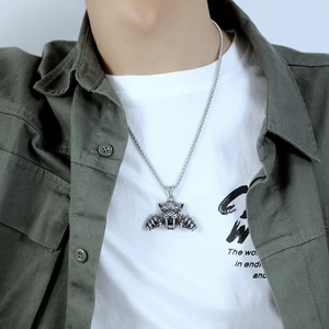 Gros plan du collier pendentif tête de tigre argentée rétro avec chaîne à billes sur homme