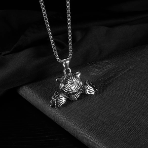 Gros plan détaillé d'un pendentif tête de tigre argenté et griffes sur collier métal