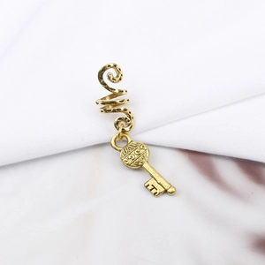 Detailed macro view of vintage gold spiral hair rings with a delicate key pendant