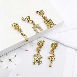 Macro detail of 5-piece vintage gold hair charms with mermaid and angel pendants