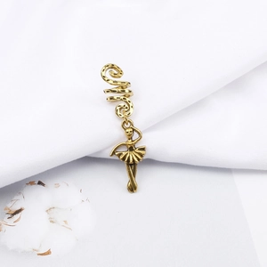 Detail of vintage gold spiral hair ring with an elegant ballerina dancer pendant charm