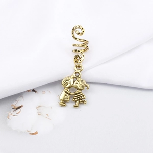 Detailed macro view of a vintage gold alloy spiral hair ring with cartoon lovers charm