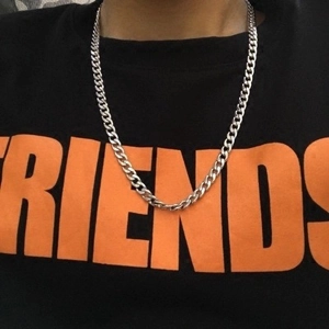 Unisex silver stainless steel curb chain necklace worn over a black and orange graphic tee