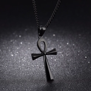 Detailed close-up of a polished black Ankh cross pendant with a metallic chain