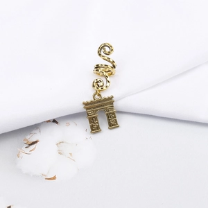 Detail of vintage gold spiral hair coil featuring a decorative Arc de Triomphe pendant