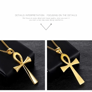 Detailed macro view of a polished gold Ankh cross pendant with a matching chain