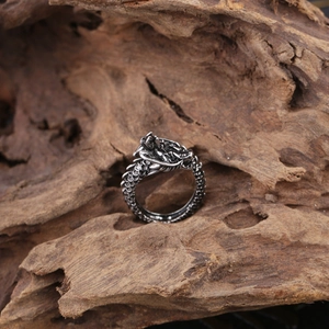 Detailed macro view of the intricate dragon scale textures and carved head on a silver ring
