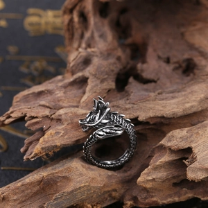 Detailed view of vintage silver dragon ring with intricate scales on rustic wood