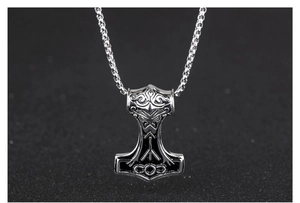 Vista detallada del colgante Mjölnir de plata con grabados de runas vikingas finas