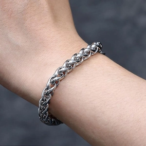 Gros plan d'un bracelet gourmette en acier inoxydable argenté sur un poignet masculin