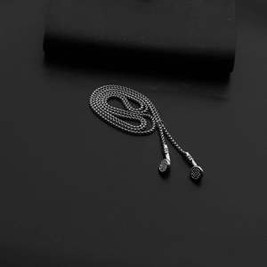 Detail of silver chain with creative headphone pendant on premium black leather