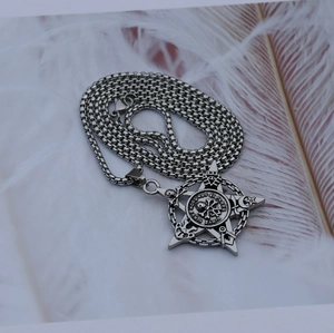 Vue détaillée du pendentif crâne de pirate pentagramme gothique sur plume blanche