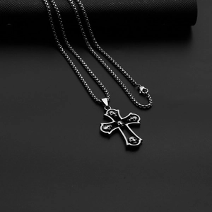 Detail view of silver punk cross pendant with gothic skulls on black leather box