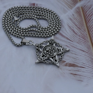 Détail macro du pendentif pentagramme argenté vintage avec crâne et symboles occultes