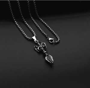 Macro detail of vintage titanium steel vajra pendant and sturdy square box chain link
