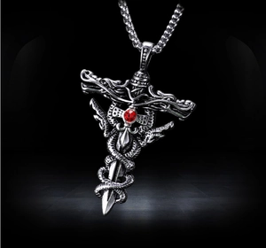Detailed view of punk style sword and snake pendant with red gemstone on a chunky chain
