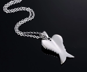 Macro detail of silver angel wing pendant necklace with realistic feather texture and chain