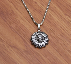 Detail of vintage silver titanium steel necklace with skull pendant and Roman numerals
