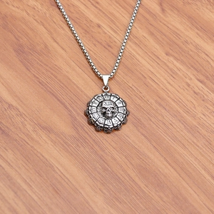 Macro view of vintage silver skull pendant with Roman numerals on wooden background