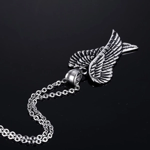 Polished silver angel wing pendant necklace with vintage oxidized texture on black mirror