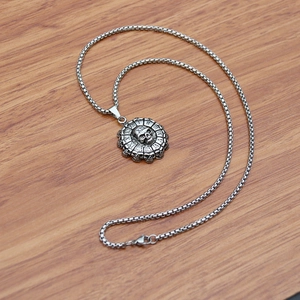 Macro view of vintage silver skull pendant with Roman numerals on stainless steel box chain