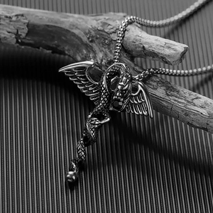 Macro shot of vintage silver dragon pendant with black gemstone on cross