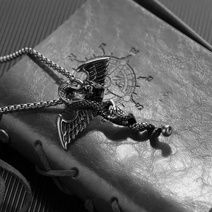 Detail of gothic dragon pendant with black gemstone on vintage leather book background
