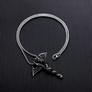 Detail of gothic dragon and winged cross pendant with a black gem on stainless steel