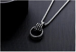 Detail of gothic stainless steel skeleton hand pendant on a vintage ball chain