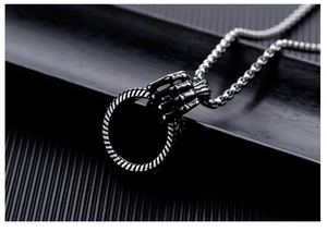 Macro shot of a punk style dragon claw pendant with a textured ring on a silver chain