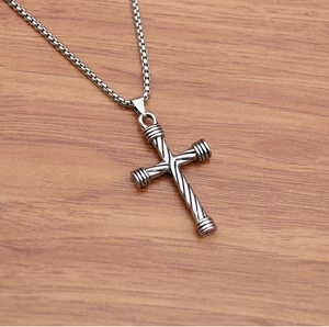 Hip hop style silver cross pendant necklace with twist rope texture on wooden background