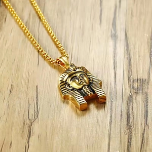 Collier pendentif pharaon égyptien doré pour homme style hip hop sur fond de bois