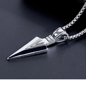Macro shot of silver spearhead pendant necklace with geometric V-shaped engraved lines